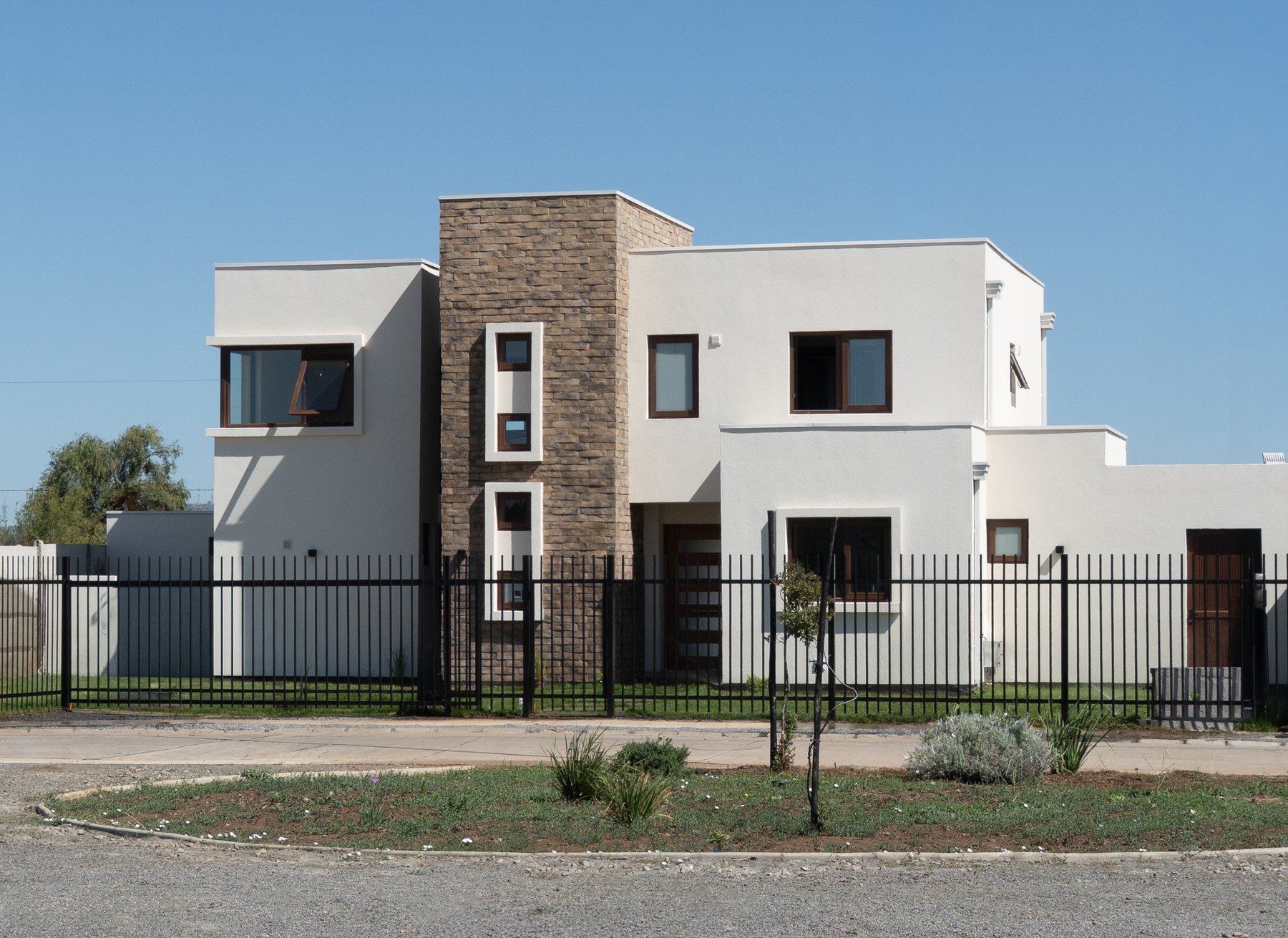 Casa de dos pisos construida en el barrio, con revestimiento de piedra